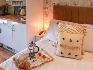 a bed with a tray of food and a pillow that says see happy at The Beehive in Mundesley