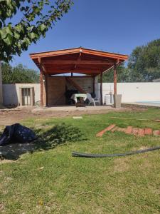 a wooden pavilion with a hose in a yard at Cabañas Los Materos in Santa María