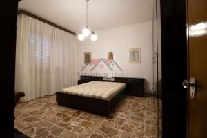 een slaapkamer met een bed in het midden van een kamer bij 2-bedroom apartment in heart of Tuscany with free parking in Pomarance