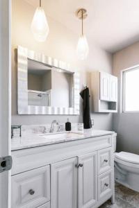 a bathroom with a sink and a toilet and a mirror at Hillside Haven in San Diego