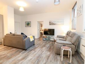 een woonkamer met 2 banken en een tv bij Apartment 7 in Lowestoft