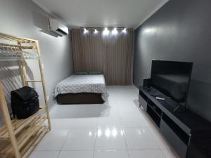 a small room with a bed and a television at Mirante de São Vicente in São Vicente