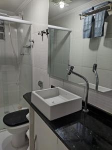a bathroom with a sink and a toilet and a shower at Mirante de São Vicente in São Vicente +20 photos