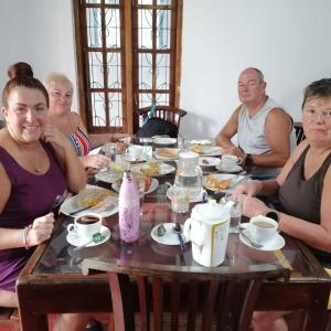 um grupo de pessoas sentadas à volta de uma mesa a comer em Thambara Resort em Pollonaruva
