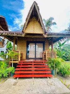 a house with a red staircase in front of it at Family Cabana at Amihan Surf Cabanas in General Luna