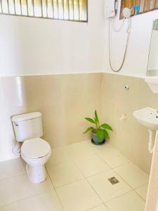 a bathroom with a toilet and a sink at Family Cabana at Amihan Surf Cabanas in General Luna