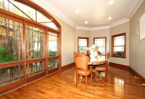 a dining room with a table and chairs and large windows at Relaxin in Dural