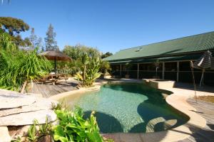 a swimming pool in a yard with a building at Relaxin in Dural