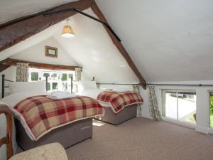 een slaapkamer met 2 bedden op een zolder bij Little Millhayes in Thorverton