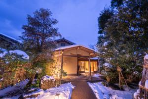 une maison dans la neige avec une allée dans l'établissement Shaga-no-Sato Yumeya, à Niigata