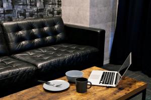 a coffee table with a laptop on a leather couch at Regalo芝浦 501 in Tokyo