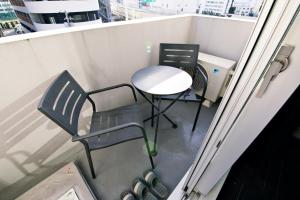 una mesa y sillas sentadas en un balcón en Regalo芝浦 501 en Tokio