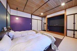 Schlafzimmer mit einem großen weißen Bett in der Unterkunft Uminone in Toyooka