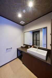 豐岡的住宿－海之聲日式旅館，一间带水槽和大镜子的浴室