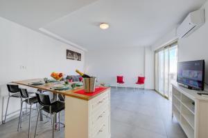 eine Küche mit einer Insel mit einer Arbeitsplatte und Stühlen in der Unterkunft Le Bristol V - Happy Rentals in Juan-les-Pins