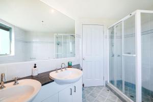uma casa de banho com 2 lavatórios e um chuveiro em The Waterford on Main Beach em Gold Coast