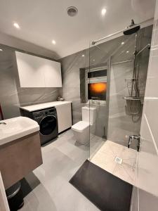 a bathroom with a shower and a toilet and a sink at Cerrkuss Stays in London