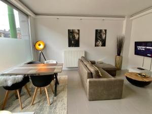 ein Wohnzimmer mit einem Sofa und einem Tisch in der Unterkunft Antwerp West Side in Zwijndrecht