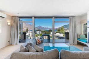 a living room with a couch and a large window at Diamond Villa - Lake Views, Central Location in Queenstown