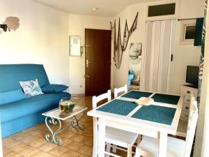 a living room with a blue couch and a table at Studio cabine avec terrasse, 4 couchages, parking privé - Marseillan - FR-1-326-415 in Marseillan