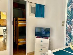 a bedroom with a tv on a dresser and a closet at Studio cabine avec terrasse, 4 couchages, parking privé - Marseillan - FR-1-326-415 in Marseillan