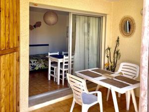 a dining room with a table and chairs in a room at Studio cabine avec terrasse, 4 couchages, parking privé - Marseillan - FR-1-326-415 in Marseillan +2 photos