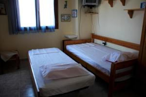 two beds in a small room with a tv at Miranta in Nikiti