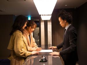 three people standing around a table with a laptop at HOTEL U's Kouroen - Vacation STAY 11270v in Nishinomiya