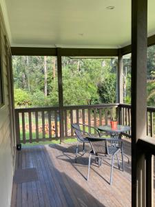 a patio with a table and chairs on a deck at Emerald Creek Cottages in Emerald
