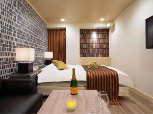 a bedroom with a bed and a table with a bottle of wine at HOTEL U's Kouroen - Vacation STAY 11277v in Nishinomiya