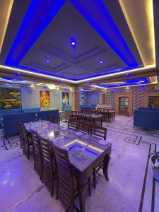 a dining room with tables and chairs and blue lights at The Asanar Hills in Rūpnagar