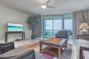 Caribe Resort Unit C201 في Romar Beach: غرفة معيشة مع أريكة وطاولة وتلفزيون