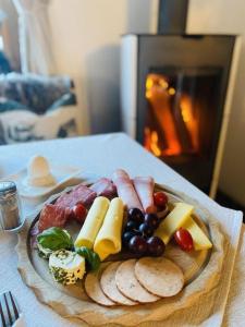 eine Platte Essen auf einem Tisch mit Fleisch und Käse in der Unterkunft Steinbock Bed & Breakfast in Fischen im Allgäu