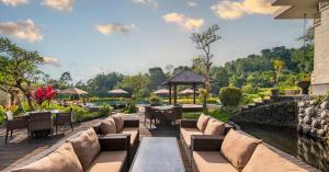 eine Terrasse in einem Resort mit Tischen und Stühlen in der Unterkunft HOMM Saranam Baturiti, Bali in Bedugul