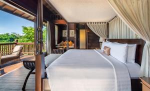 a bedroom with a bed and a balcony at HOMM Saranam Baturiti, Bali in Bedugul