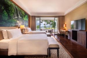百度庫的住宿－HOMM Saranam Baturiti, Bali，酒店客房设有两张床和一台平面电视。