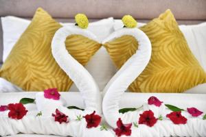 Al Salam Hotel في الكويت: اثنين من البجعات مصنوعة من المناشف على سرير