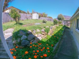 une cour avec un jardin fleuri et une clôture dans l'établissement Sunny, Spacious mountain views, Holiday home, à Lenah Valley