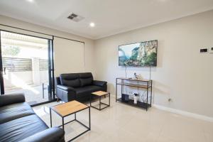 a living room with a couch and a table at Gorgeous Family House near Shops in Perth