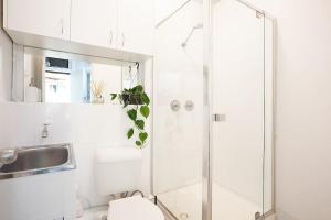 a bathroom with a shower and a toilet and a sink at Large 4 Bed Beachside Haven 50m to Bondi Beach in Sydney
