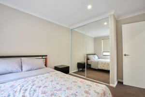 um quarto com uma cama e um espelho em Gorgeous Family House near Shops em Perth