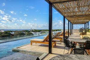 a resort with a swimming pool with tables and chairs at Kaab South Beach #309 in Playa del Carmen