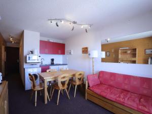 a living room with a table and a red couch at Appartement Auris, 4 pièces, 8 personnes - FR-1-297-46 in Auris