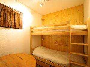 a room with two bunk beds and a table at Appartement Auris, 4 pièces, 8 personnes - FR-1-297-46 in Auris