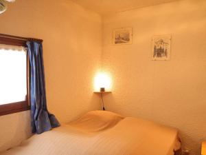 a bedroom with a bed with a lamp and a window at Appartement Auris, 2 pièces, 6 personnes - FR-1-297-11 in Auris