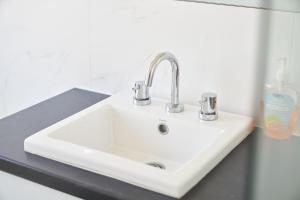a white sink with two faucets on a counter at Gorgeous Family House near Shops in Perth