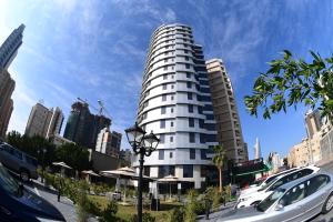 a tall white building with cars parked in front of it at Al Salam Hotel in Kuwait