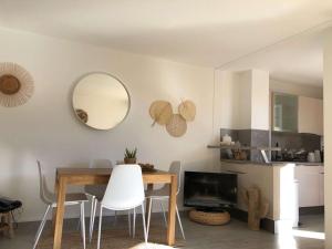 een eetkamer met een tafel en een spiegel bij Appartement Cavalière, 3 pièces, 5 personnes - FR-1-308-137 in Le Lavandou