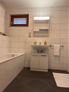a white bathroom with a sink and a mirror at Walensee Apartment, Lake & Alpine Dream in Unterterzen +27 photos