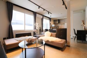 sala de estar con sofá y mesa en TAKETO STAY Sumikawa House en Sapporo